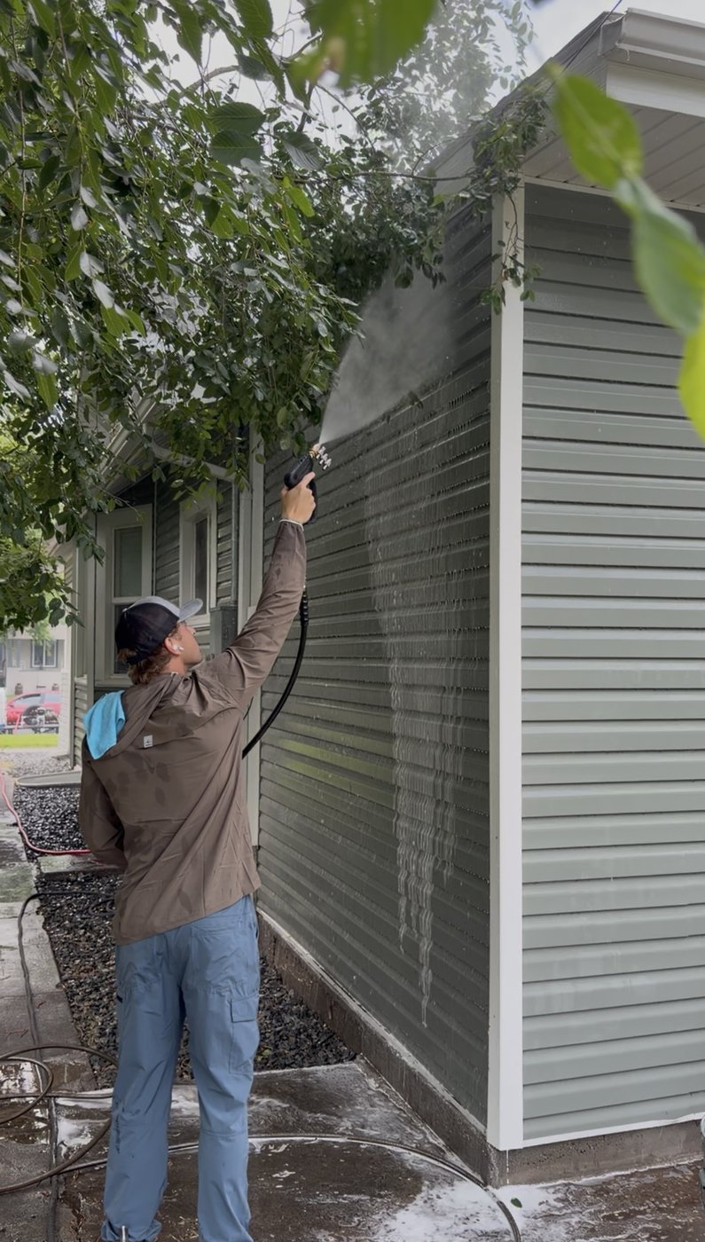 Tyler from Peak Pressure Washing washing a home exterior